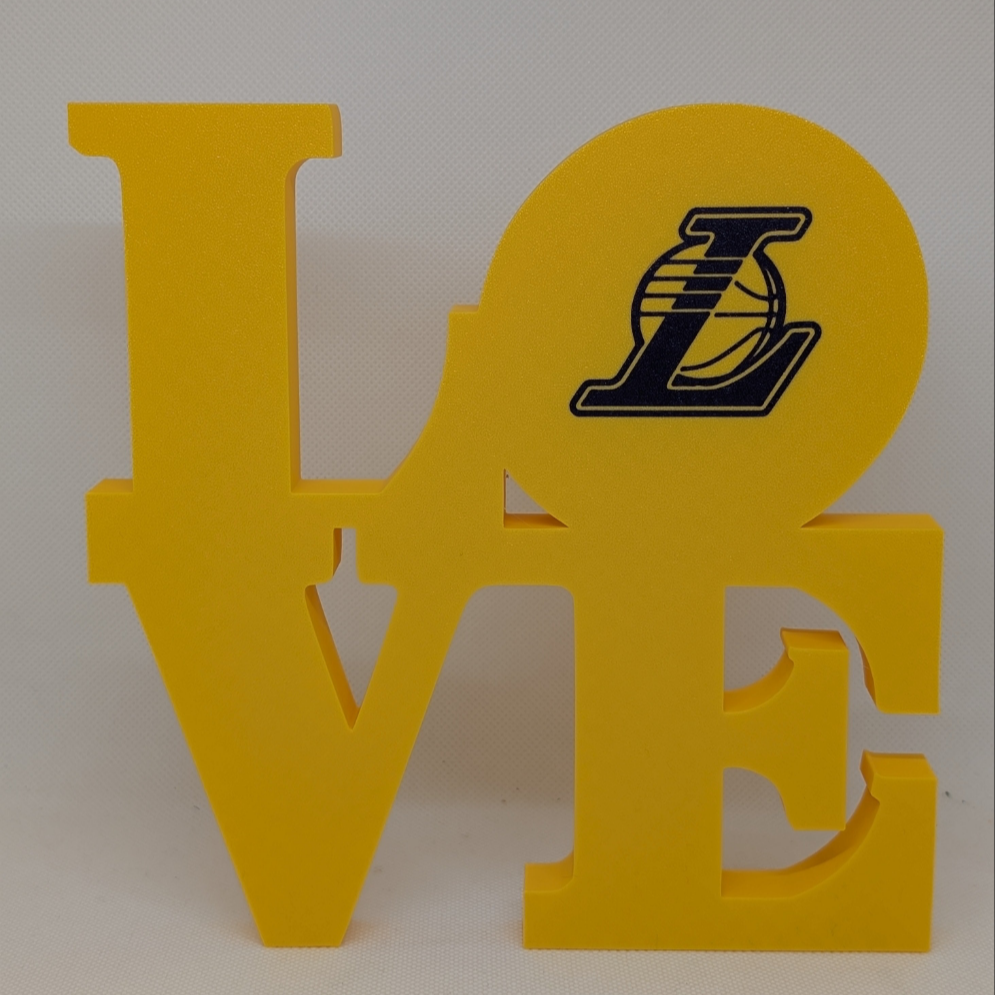 Yellow 'LOVE' decorative sign with a logo on an off-white background