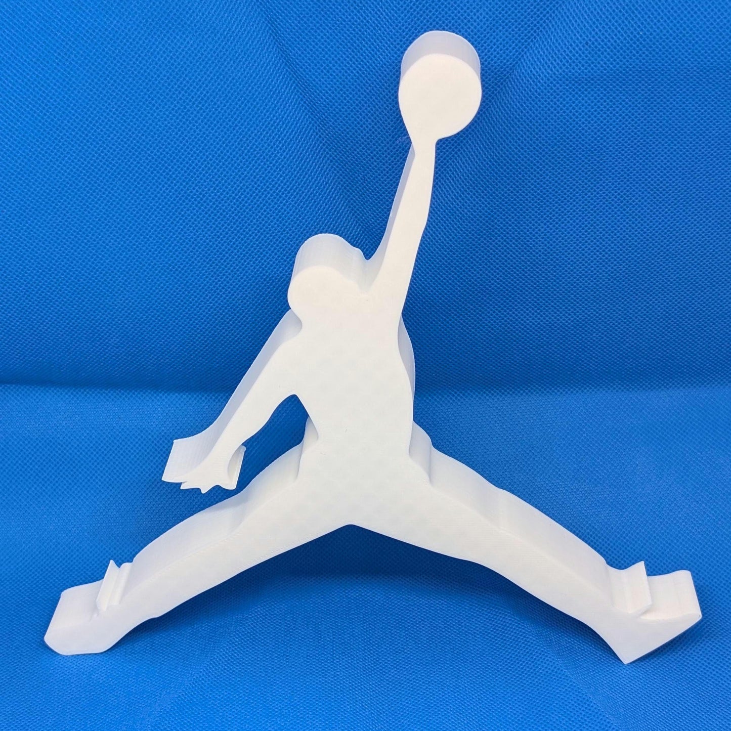 White 3D-printed figure in a dynamic pose on a blue background