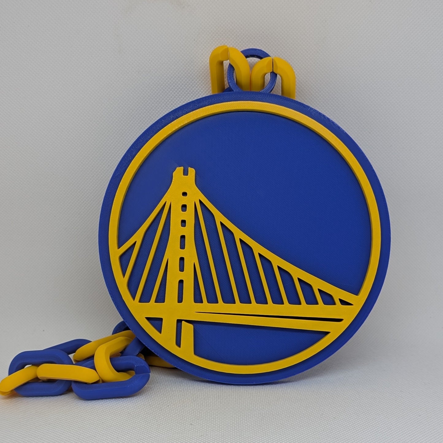 Blue and yellow keychain with a bridge design on a white background