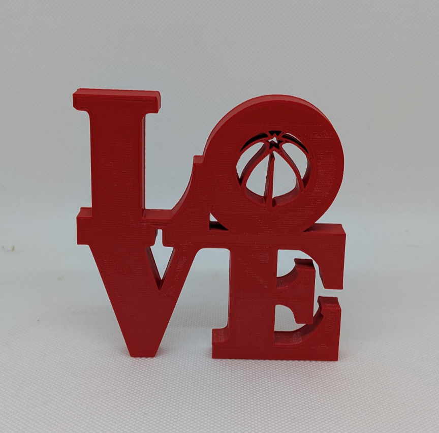 Red 'LOVE' letter sculpture on a white background