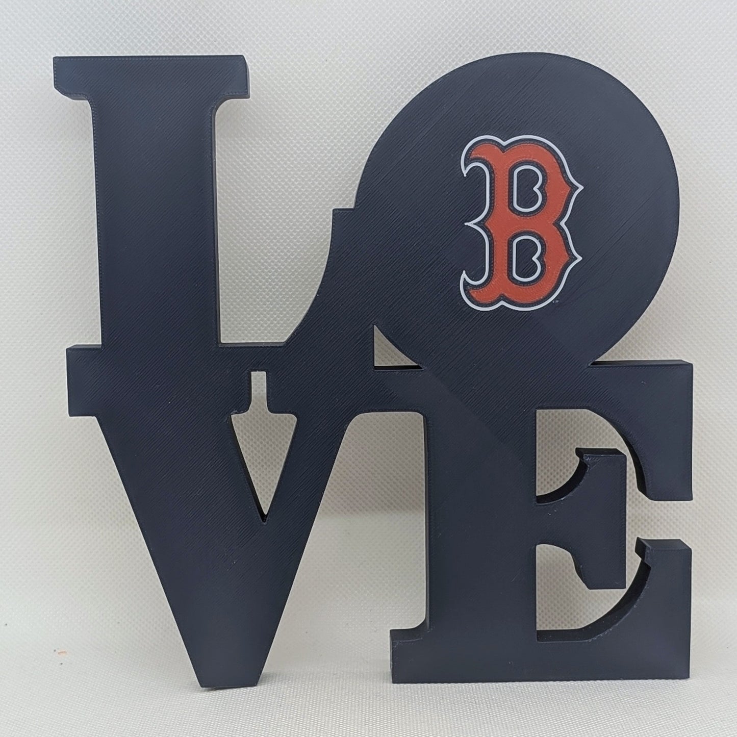 Decorative wall art with 'LOVE' letters and a red 'B' on a white background