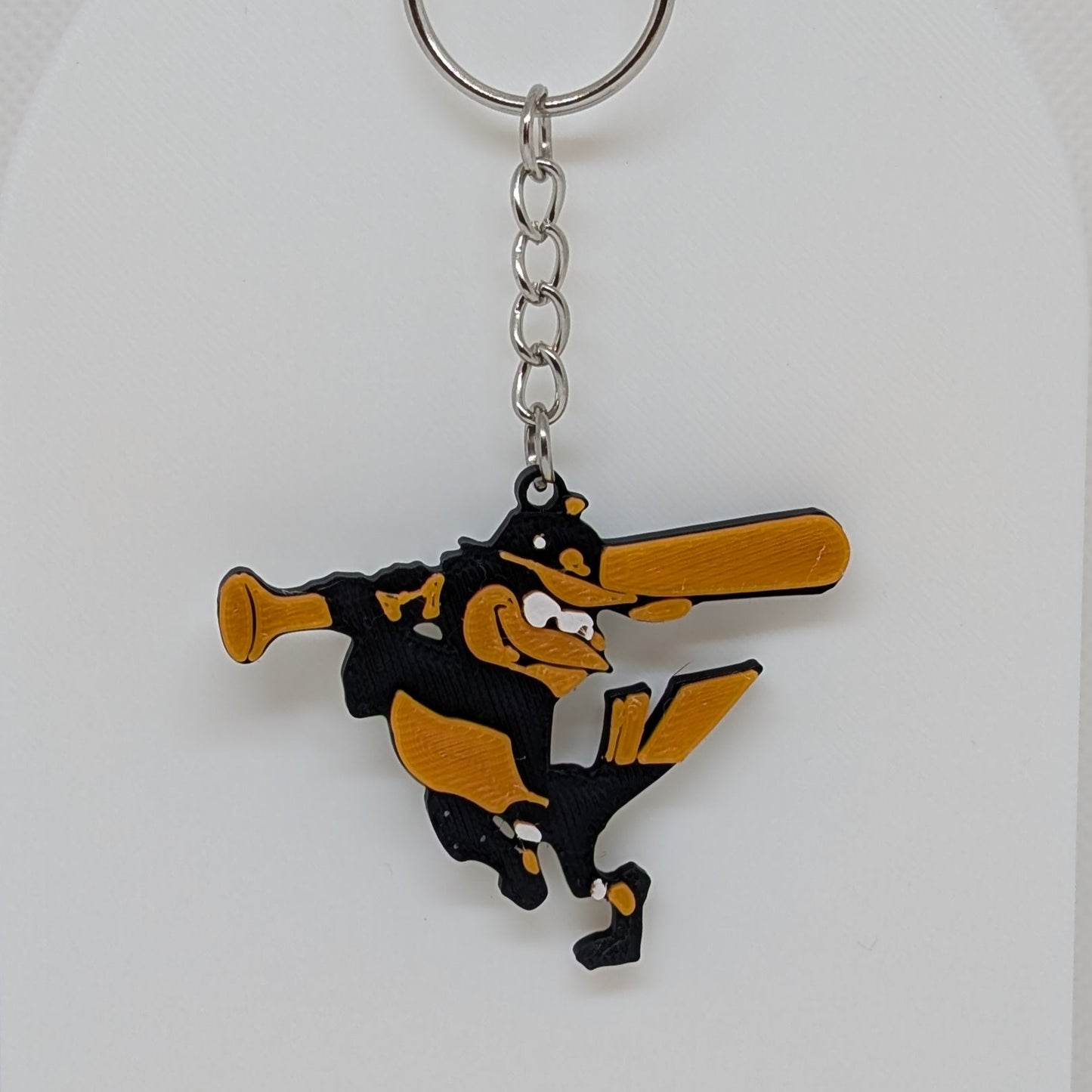 Keychain with Orioles Bird character holding a bat on a white stand