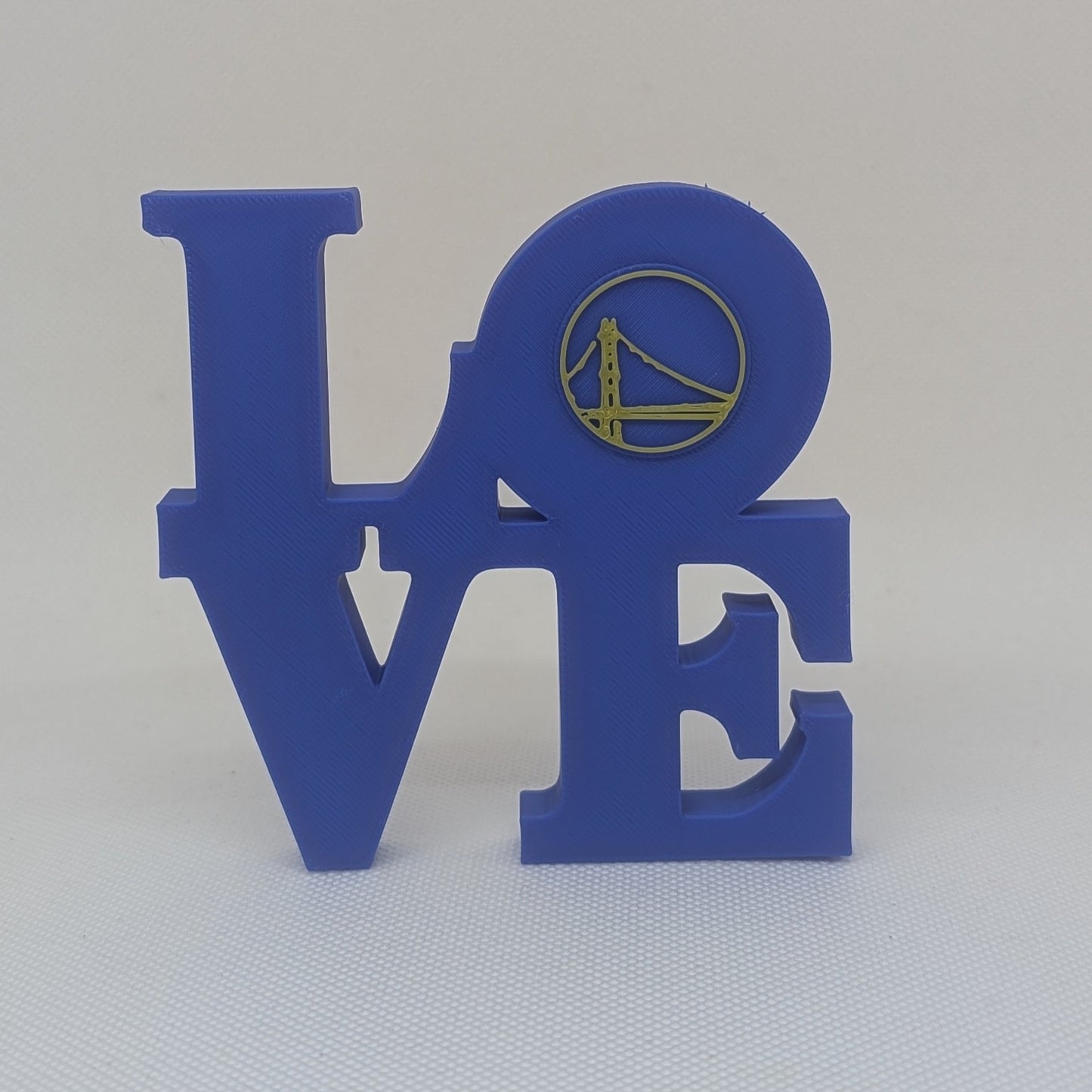 Blue decorative letters spelling 'LOVE' with a small logo on a white background