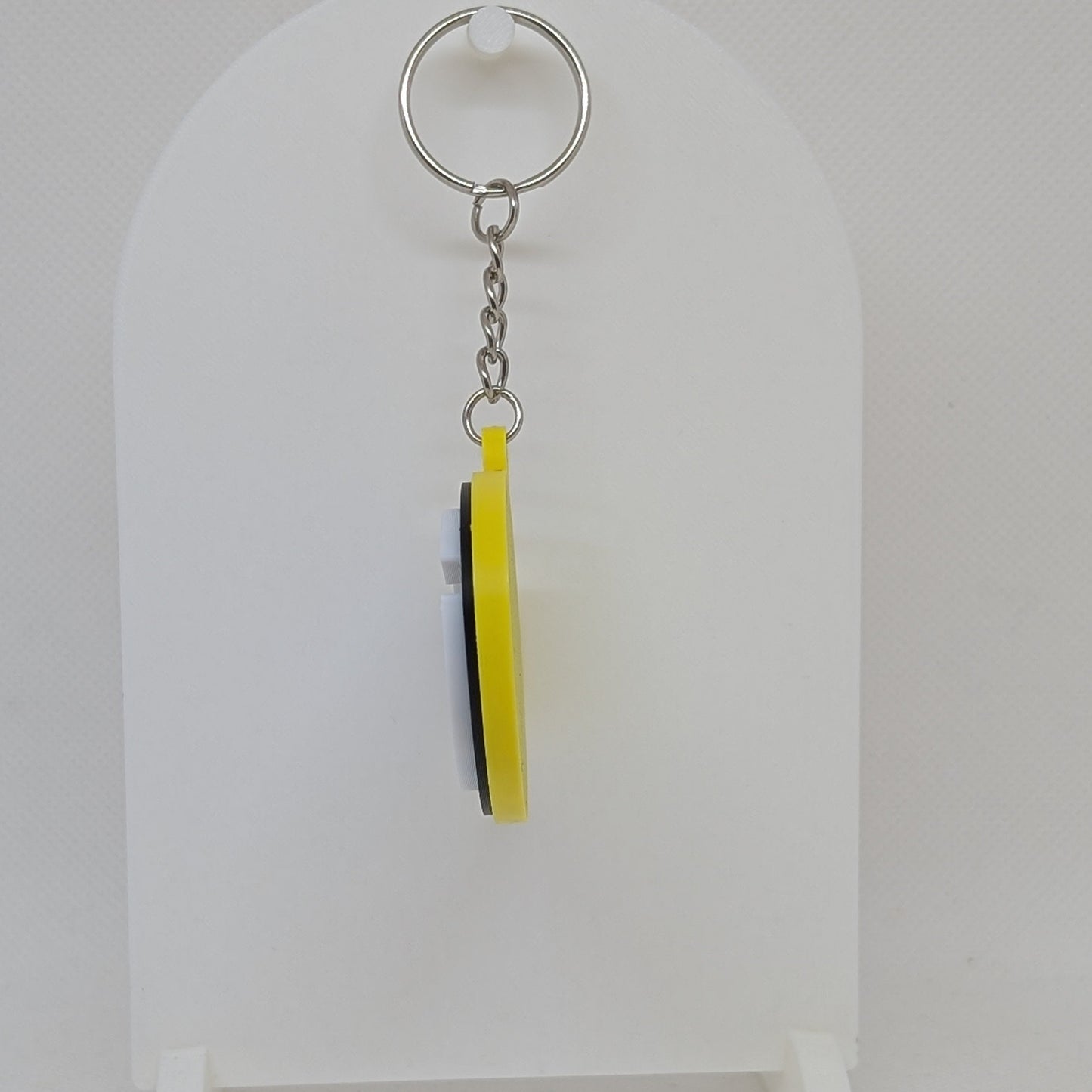 Packers Keychain with a yellow tag on a white stand against a light gray background