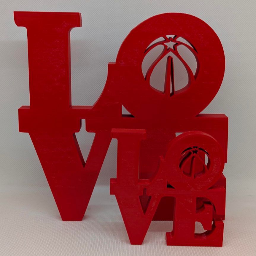 Red 'LOVE' decorative item with cut-out basketball designs on a white background