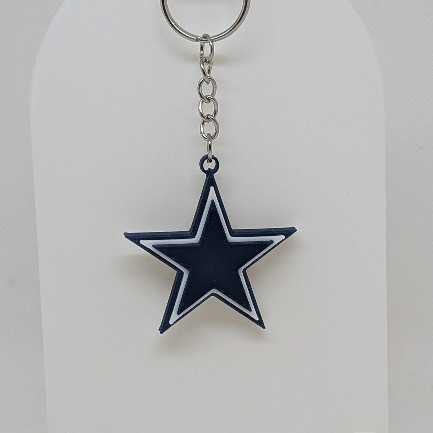 Dallas Cowboys Keychain with star design on a white stand