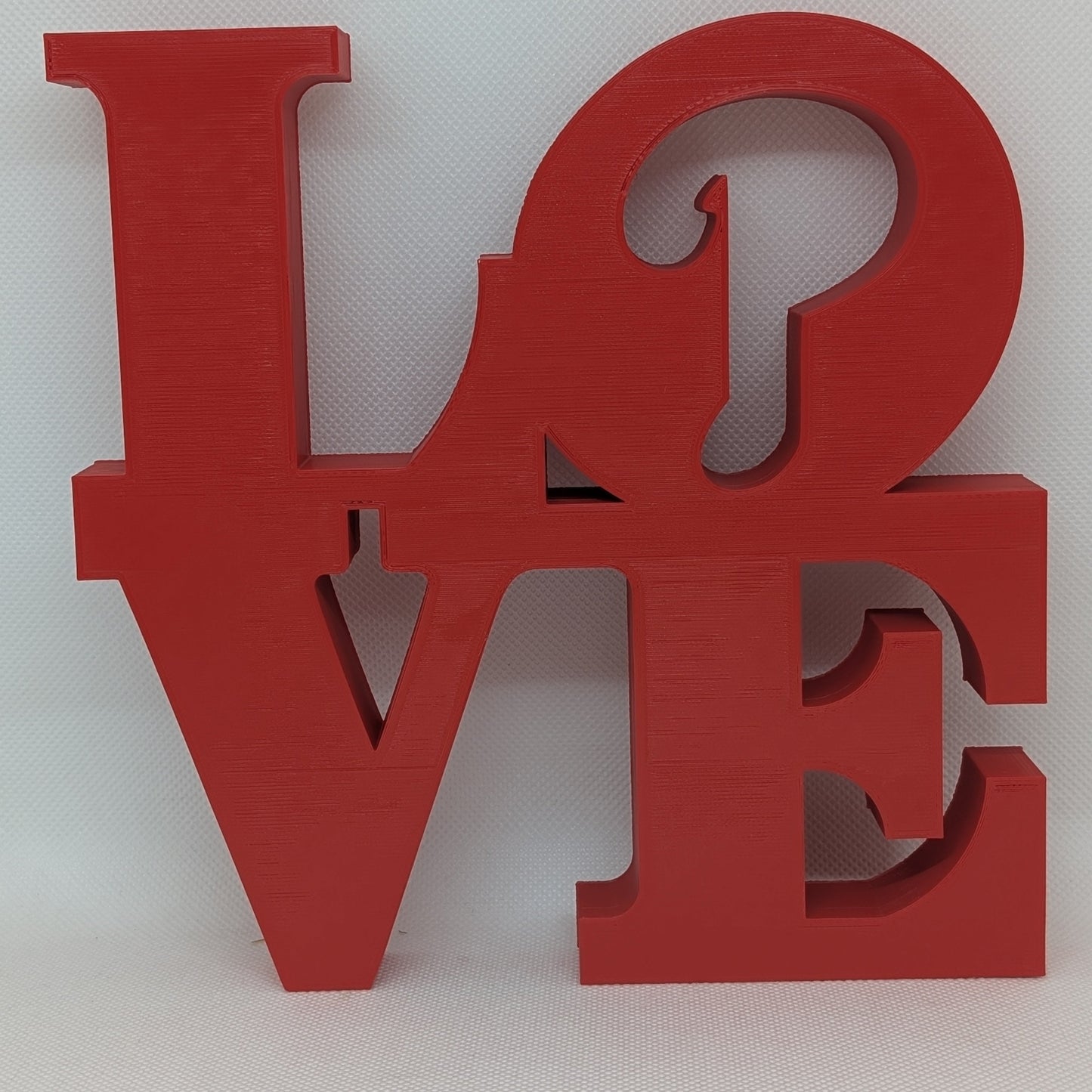 Red 'LOVE' letter sculpture on a white background