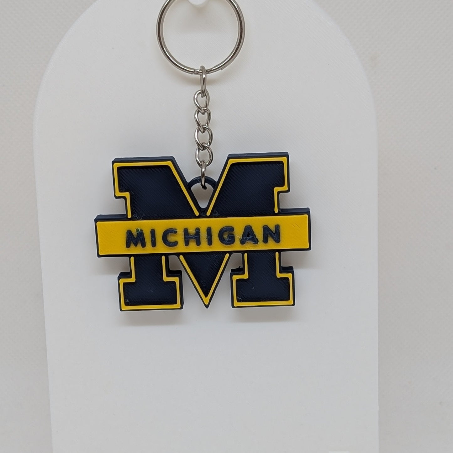 Keychain with 'Michigan' letter 'M' on a white stand