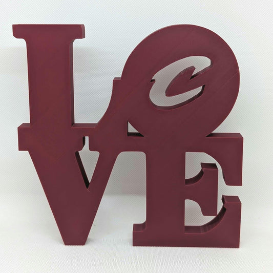 Maroon 'LOVE' letter sculpture on a white background