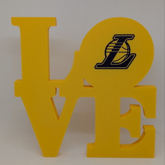Yellow 'LOVE' decorative sign with a logo on an off-white background