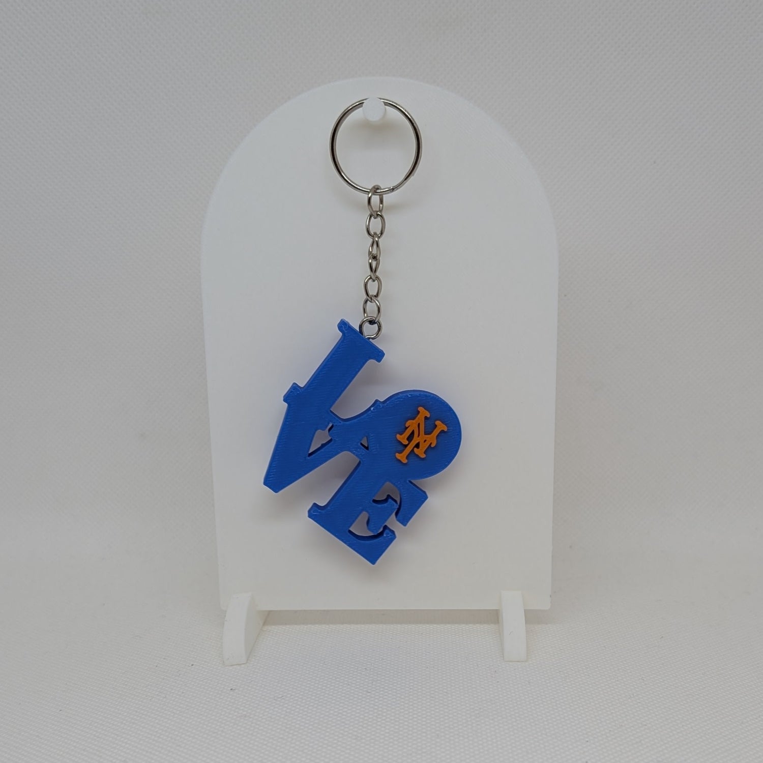 Mets Blue keychain with a design on a white card against a white background