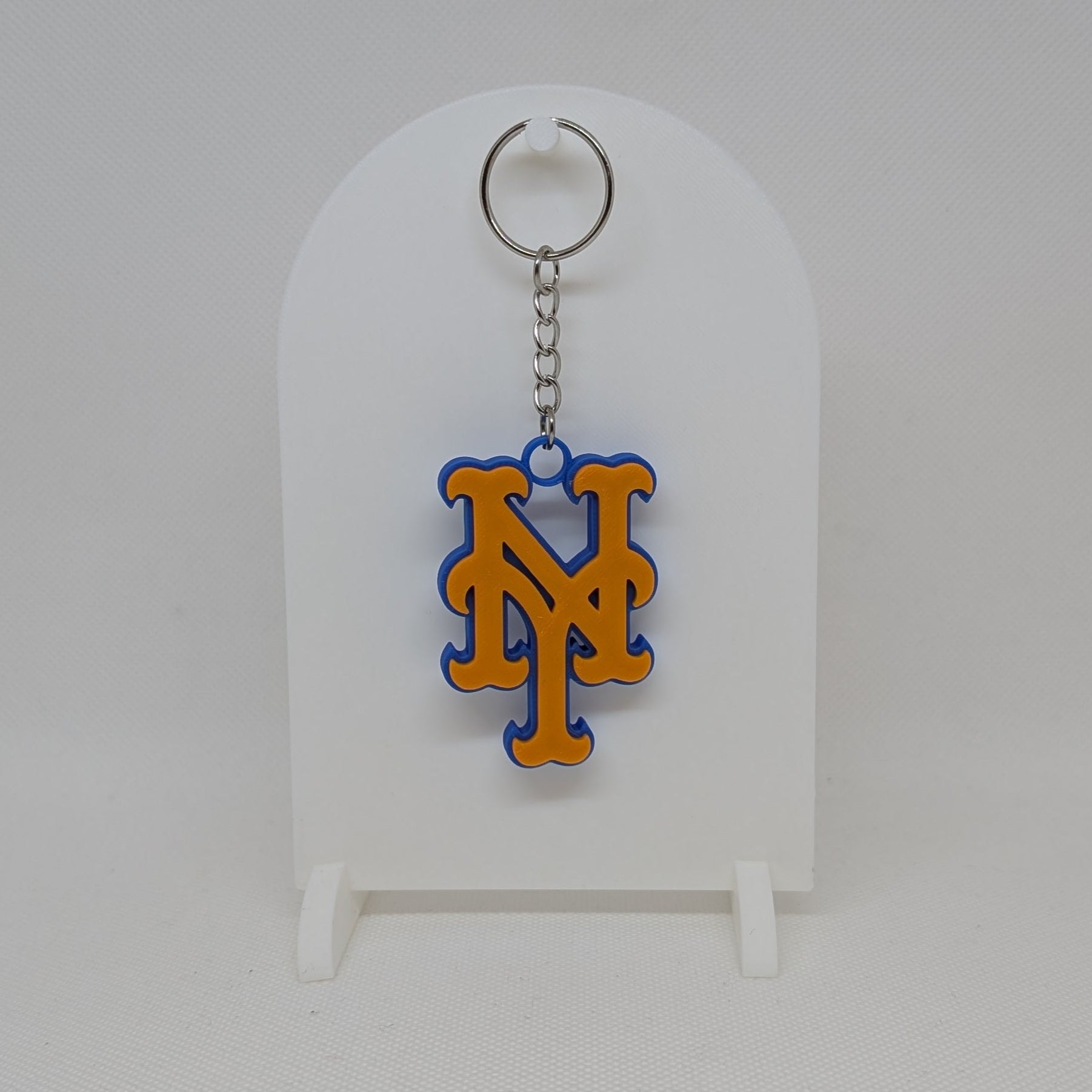 Mets Keychain with a logo on a white stand against a white background