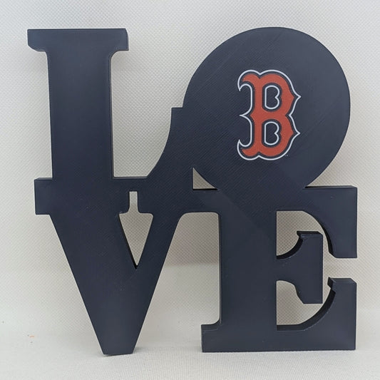 Decorative wall art with 'LOVE' letters and a red 'B' on a white background