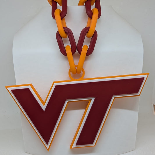 Decorative item with red and orange chain and 'VT' logo on a white background