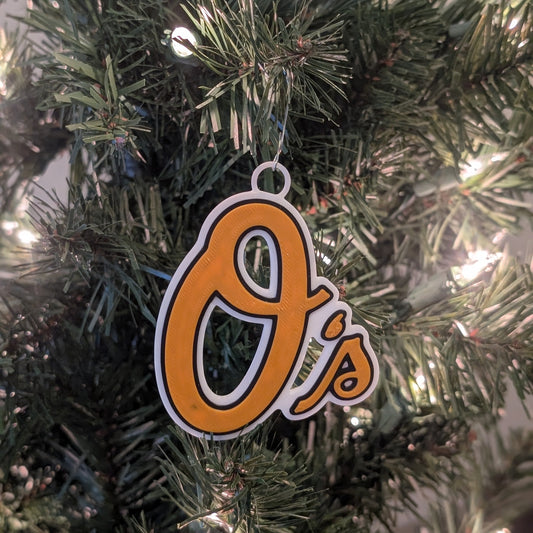 Christmas tree ornament with Orioles logo hanging on a tree