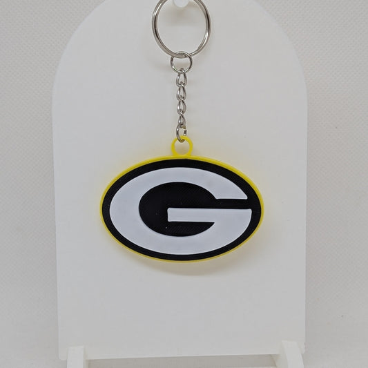 Packers Keychain with a logo on a white stand against a light gray background