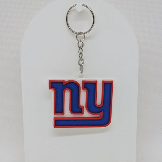Keychain with 'ny' Giants logo on a white stand against a white background