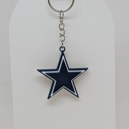 Dallas Cowboys Keychain with star design on a white stand