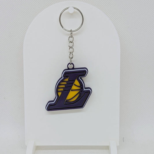 Lakers Keychain with a logo on a white stand against a light gray background