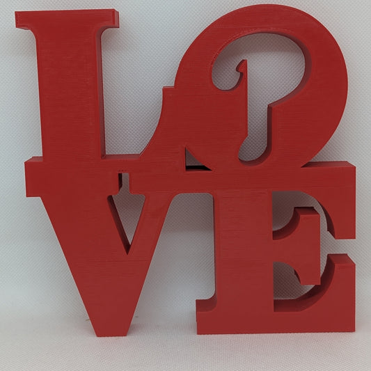 Red 'LOVE' letter sculpture on a white background