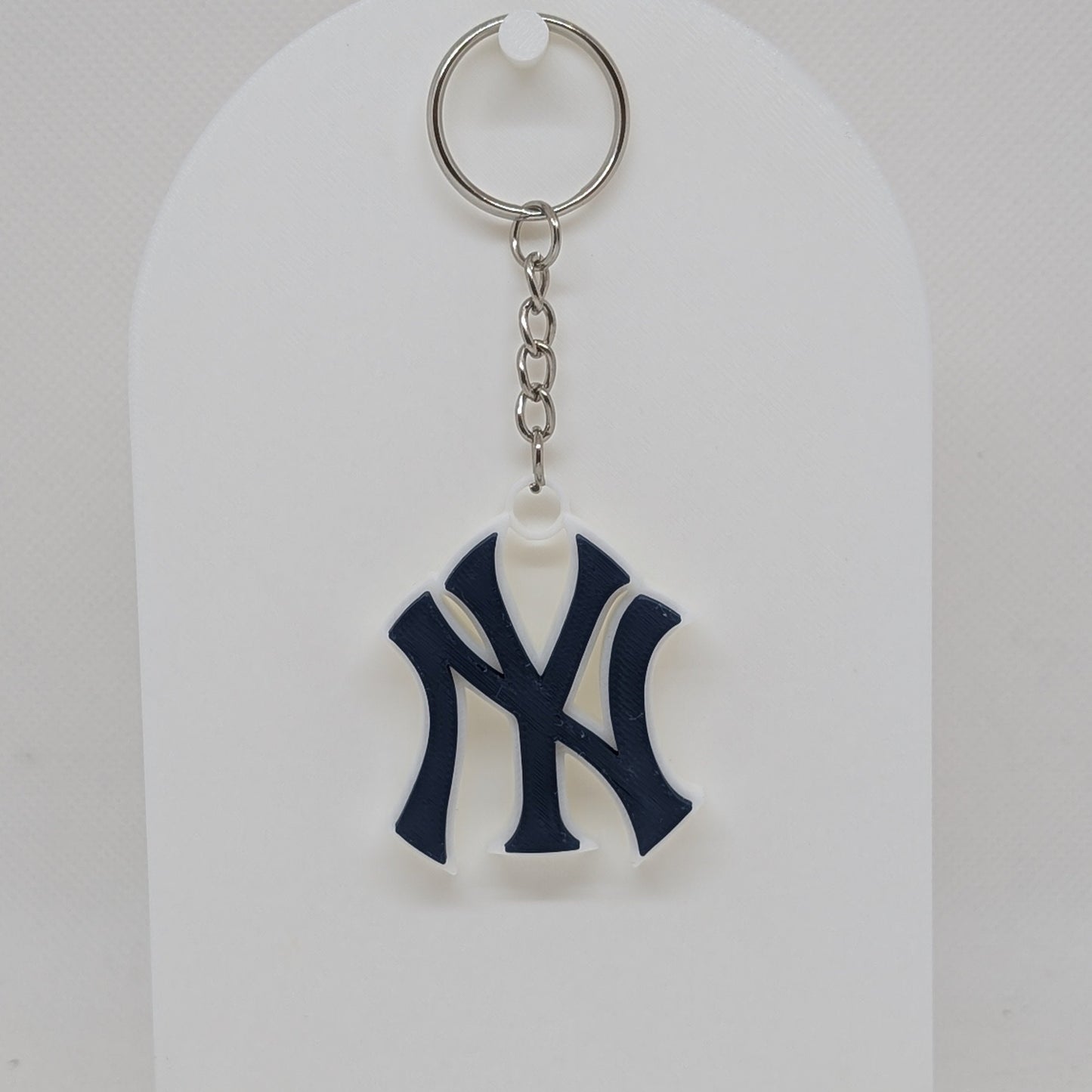 Keychain with a logo on a white stand against a white background
