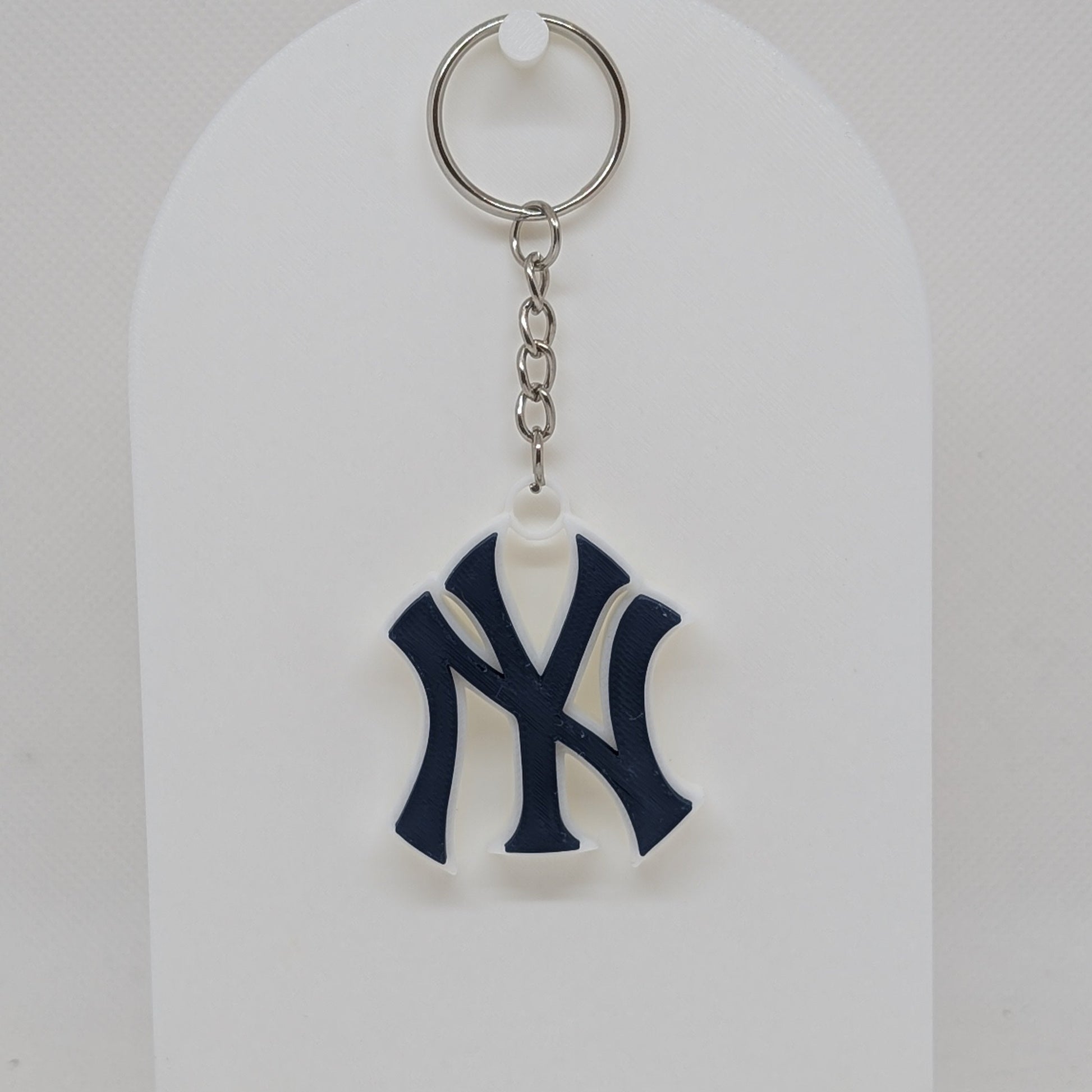 Keychain with a logo on a white stand against a white background