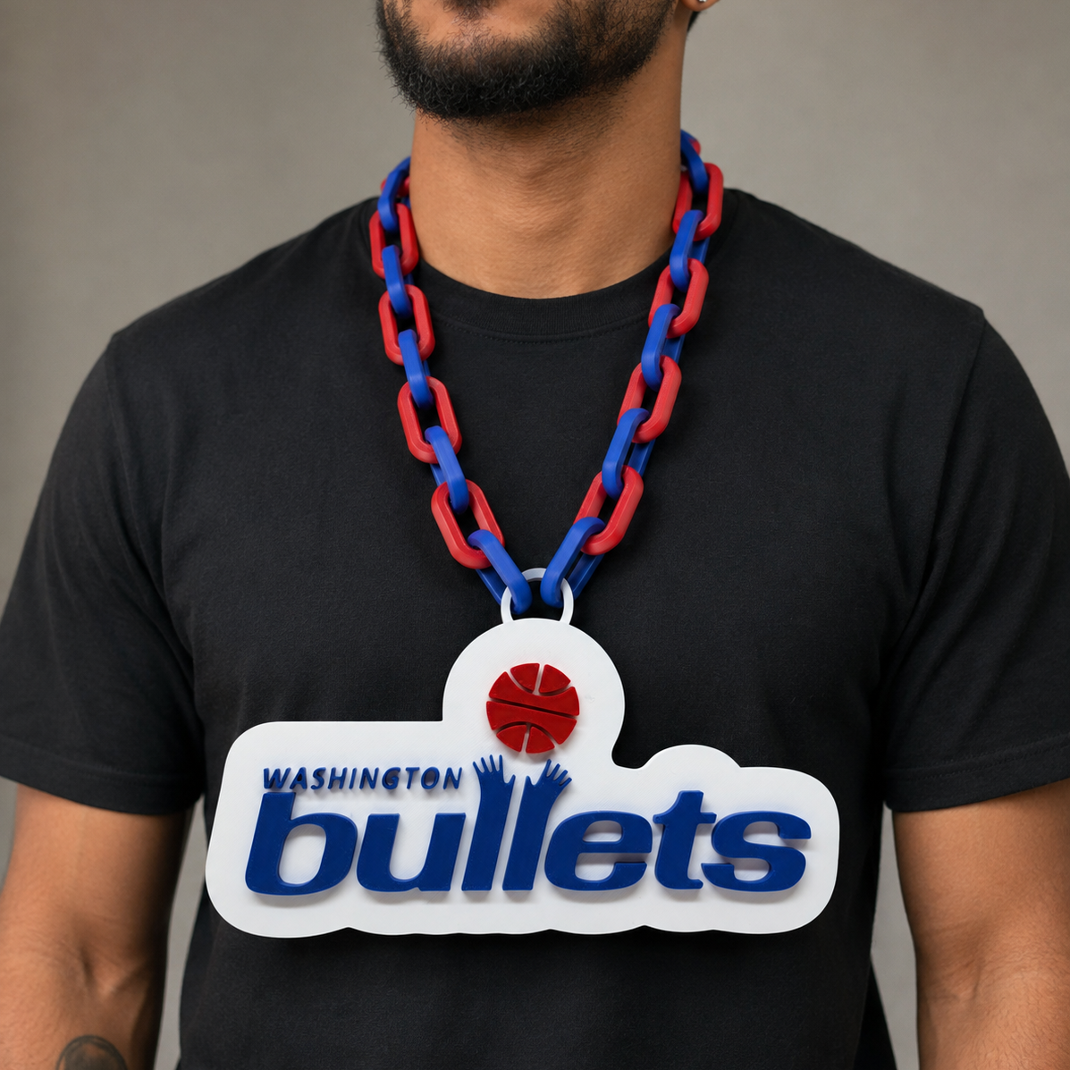 A man wearing a black t-shirt and a red and blue chain necklace with a large Washington Bullets pendant.