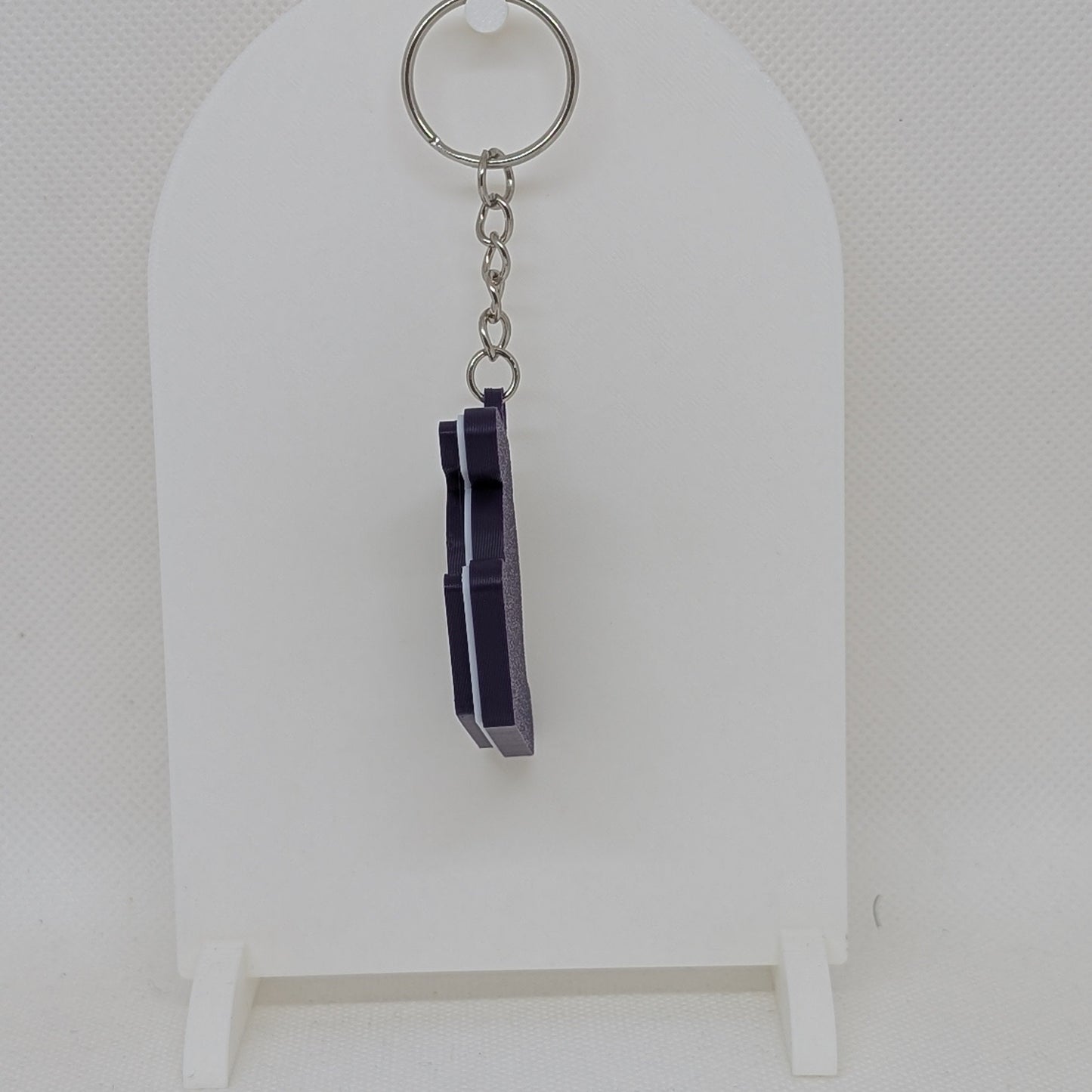 Lakers Keychain with purple crystals on a white stand against a white background
