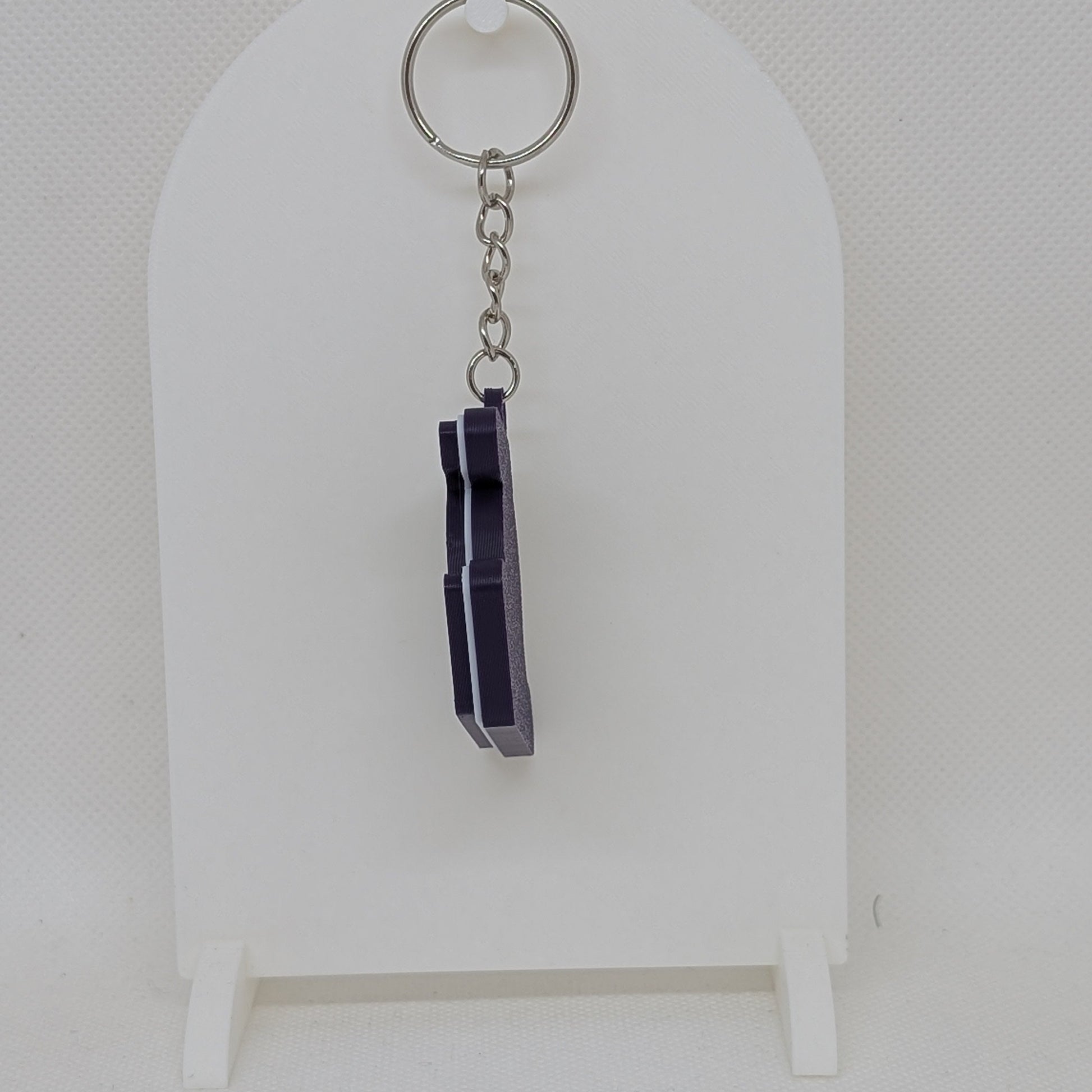Lakers Keychain with purple crystals on a white stand against a white background